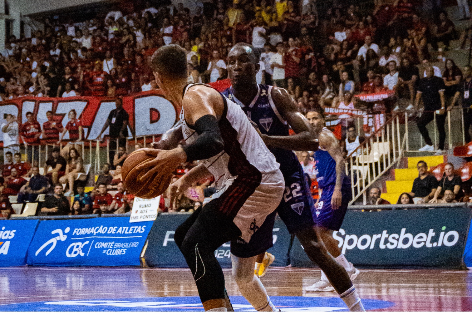 Disputa de basquete em quadra lotada